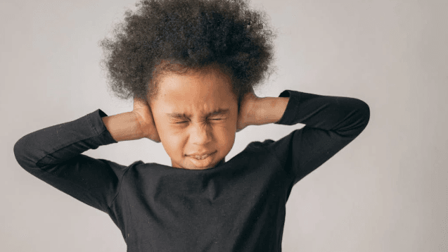 african child covering ears with eyes closed