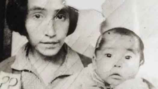 an Unagax woman and daughter numbered and photographed for POW records...