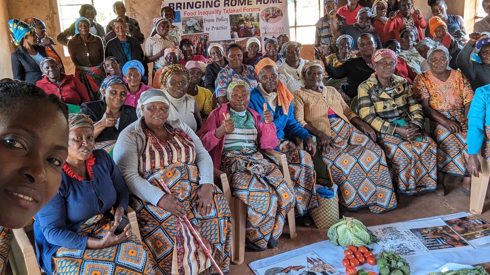 The image is of women during a community dialogue on food inequality 