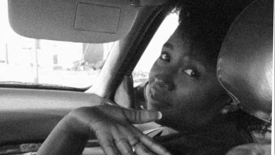 The author sitting in the passenger side of a car and waving goodbye to the backseat