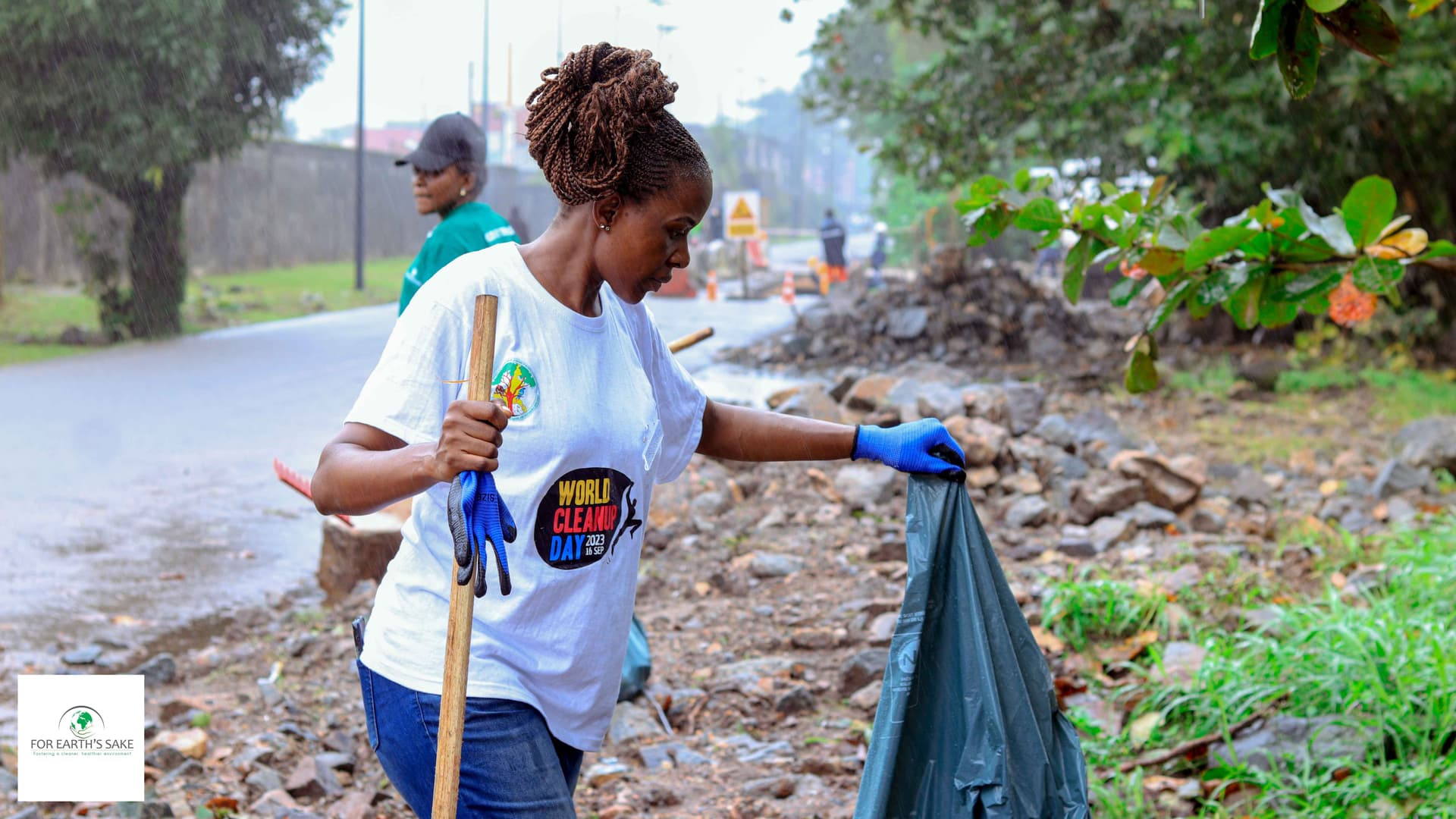 Volunteer in white tshirt, holding a dark green trash bag