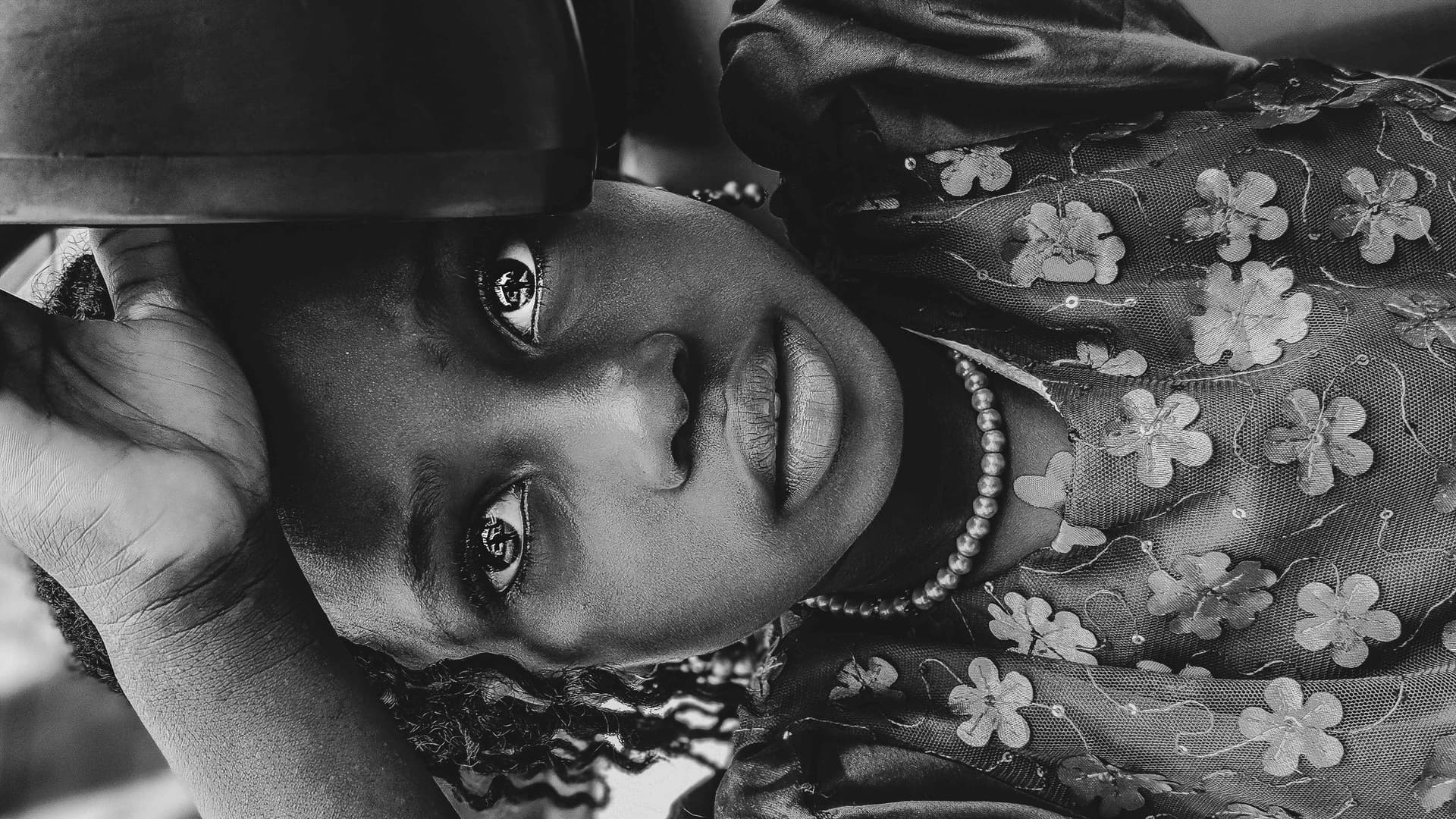 The photo shows a young black girl, about age 7/8. There is a sadness in her eyes. The photo embodies the emotion conveyed in the story.