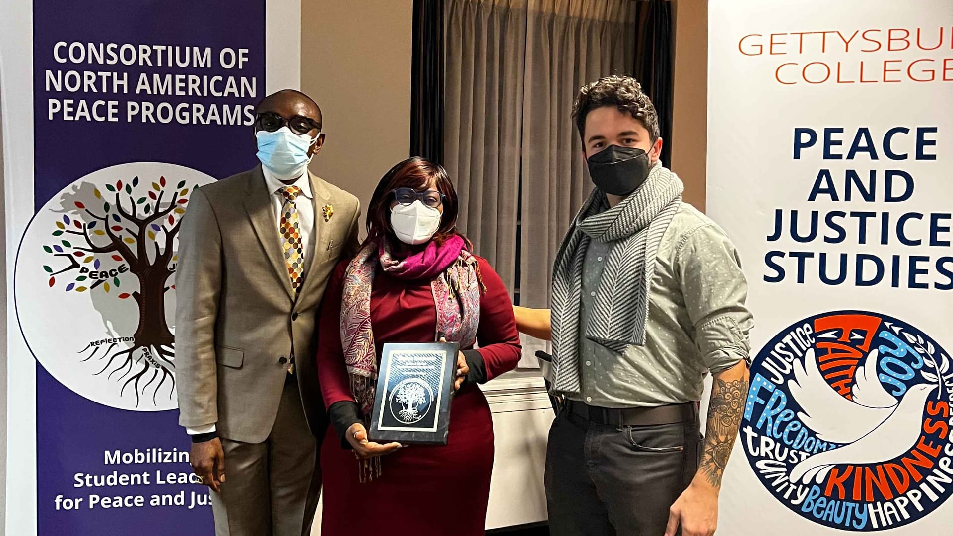Sherna Alexander Benjamin with two professors as she is awarded a Fellowship Plaque from Gettsburgh College Peace Studies Program
