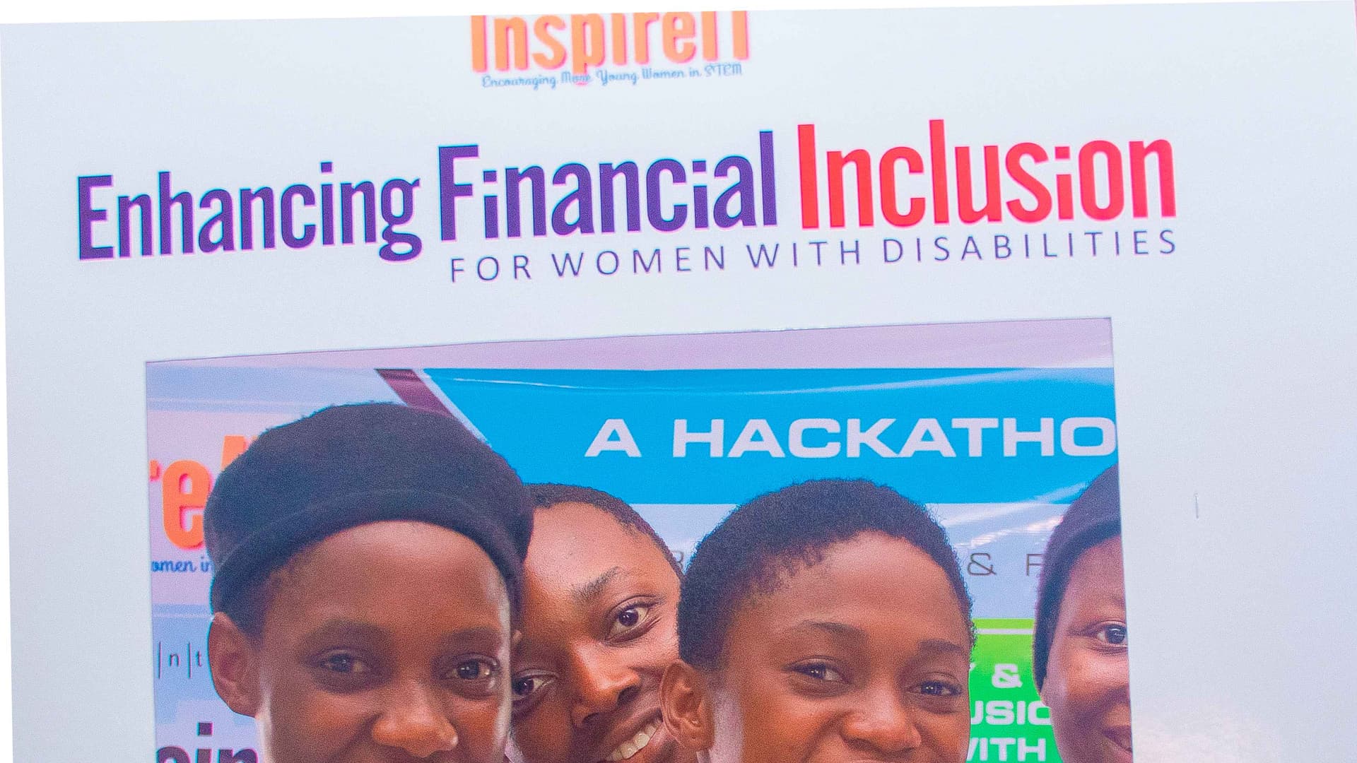 Young women smiling during InspireIT hackathon event.