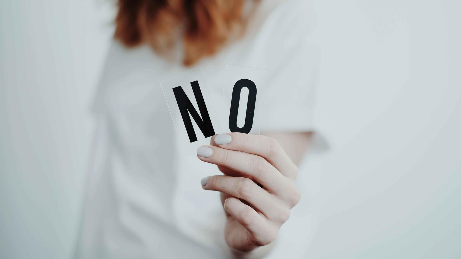 Woman holding up the letters "N" and "O" to represent boundaries