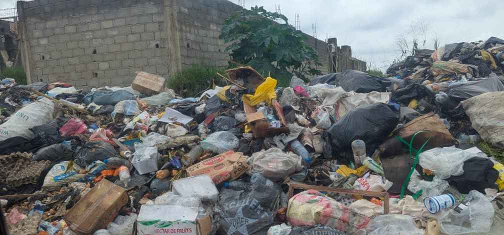 Large pile of mixed waste, including plastics, food waste and other refuse, dumped in the open at Bwitingi Market in Buea.